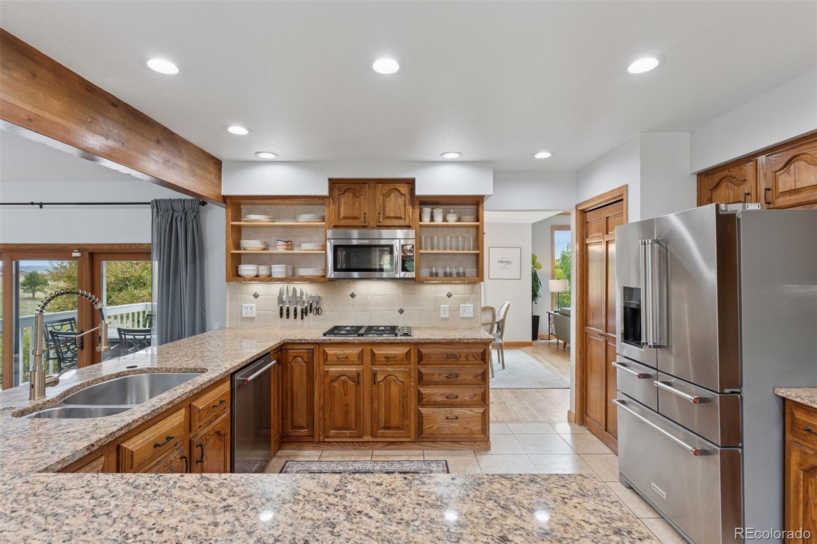 7501 Stroh Road Parker, CO 80134 - Photo 9 of 49 a kitchen with stainless steel appliances granite countertop a sink stove and refrigerator