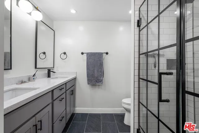 a bathroom with a double vanity sink toilet and shower