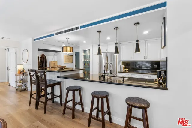 a kitchen with stainless steel appliances a table and chairs in it