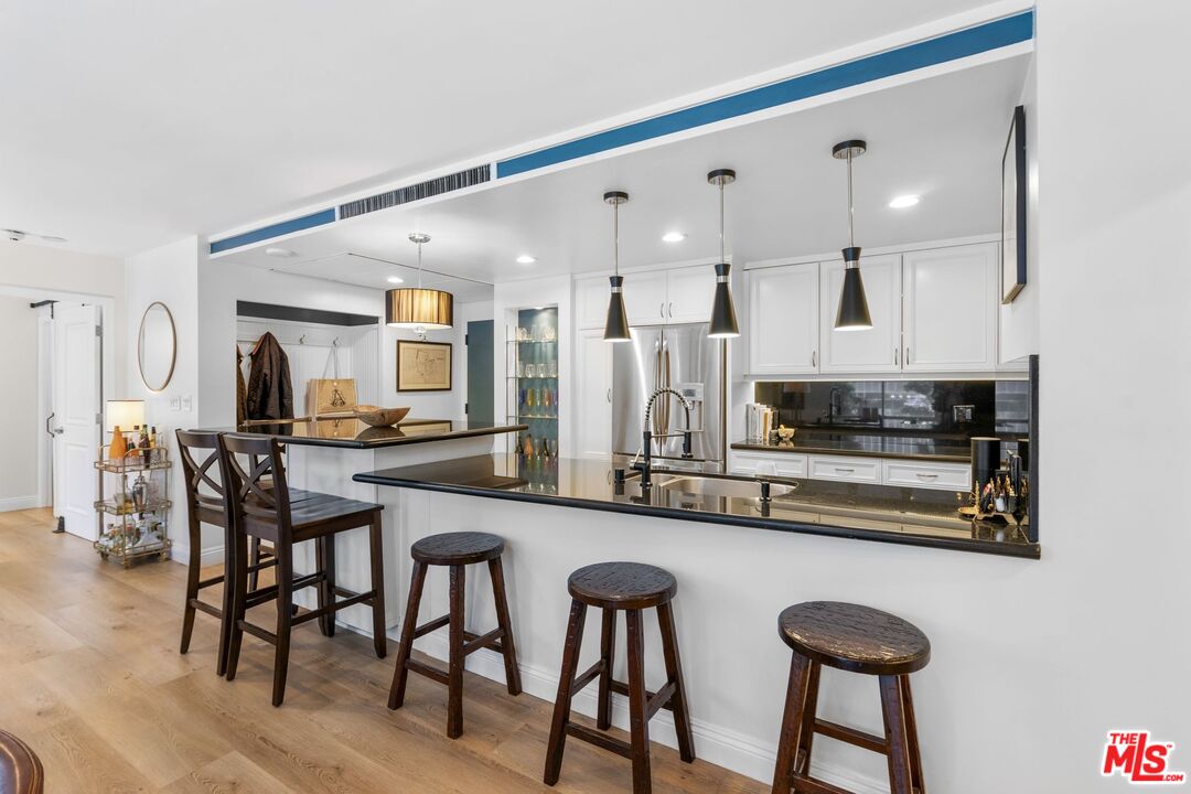 2160 Century Park East, Unit 211 Los Angeles, CA 90067 - Photo 8 of 24 a kitchen with stainless steel appliances a table and chairs in it