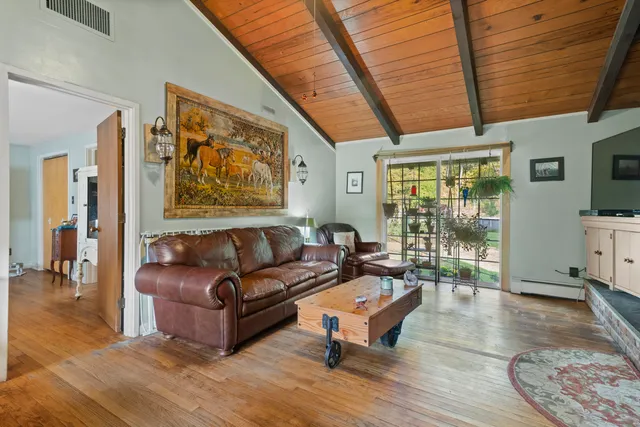 a living room with furniture a wooden floor and a large window