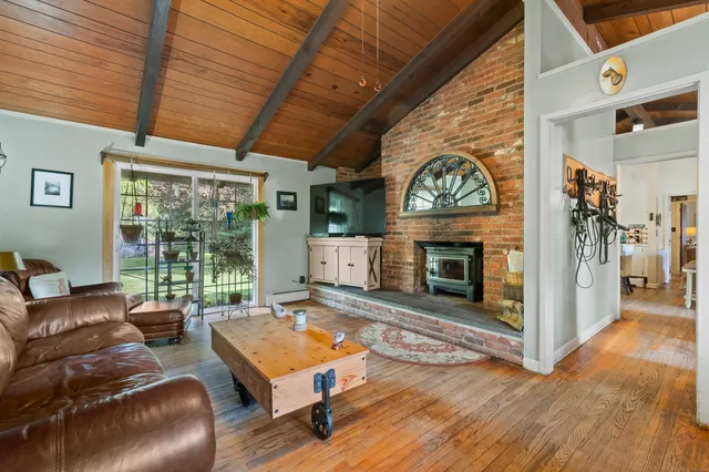 a living room with furniture fireplace and a large window