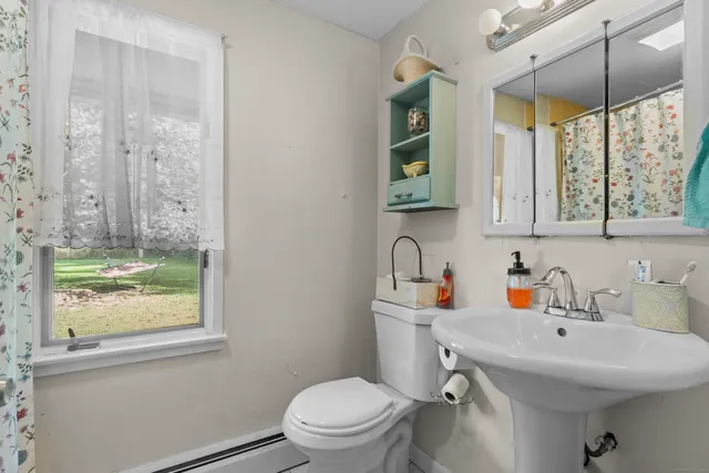 a bathroom with a sink a toilet and a window