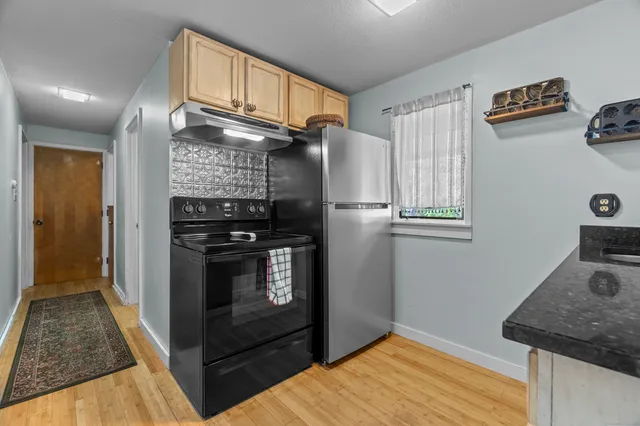 a kitchen with stainless steel appliances granite countertop a refrigerator and a stove