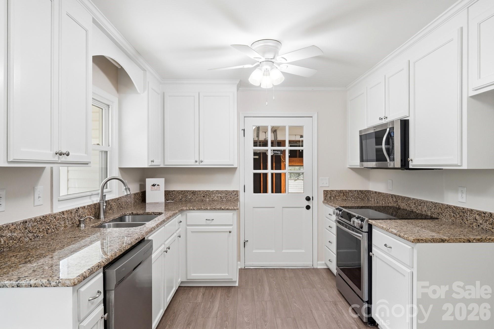 1235 Winecoff School Road Concord, NC 28027 - Photo 7 of 27 a kitchen with granite countertop cabinets stainless steel appliances a sink and wooden floor