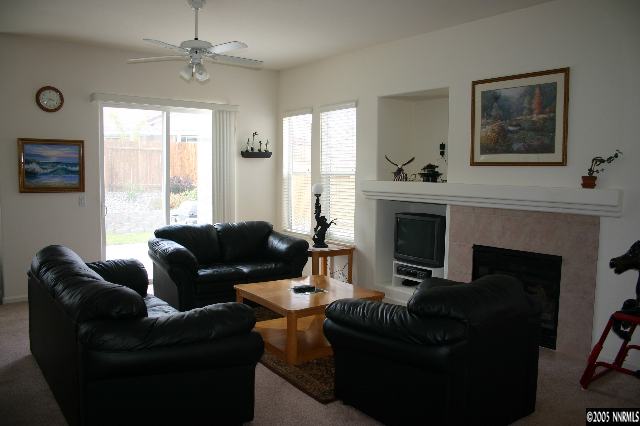 1251 Edgehill Court Reno, NV 89521 - Photo 4 of 6 a living room with furniture a large window and a fireplace