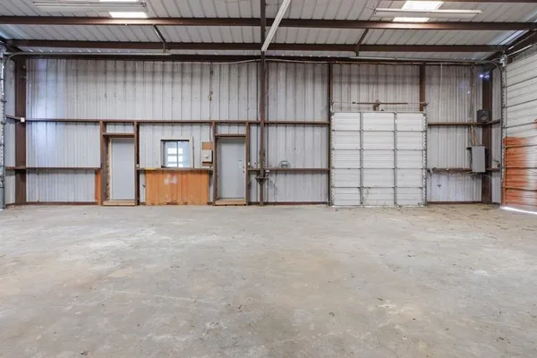 a view of an empty room with a fireplace and wooden floor