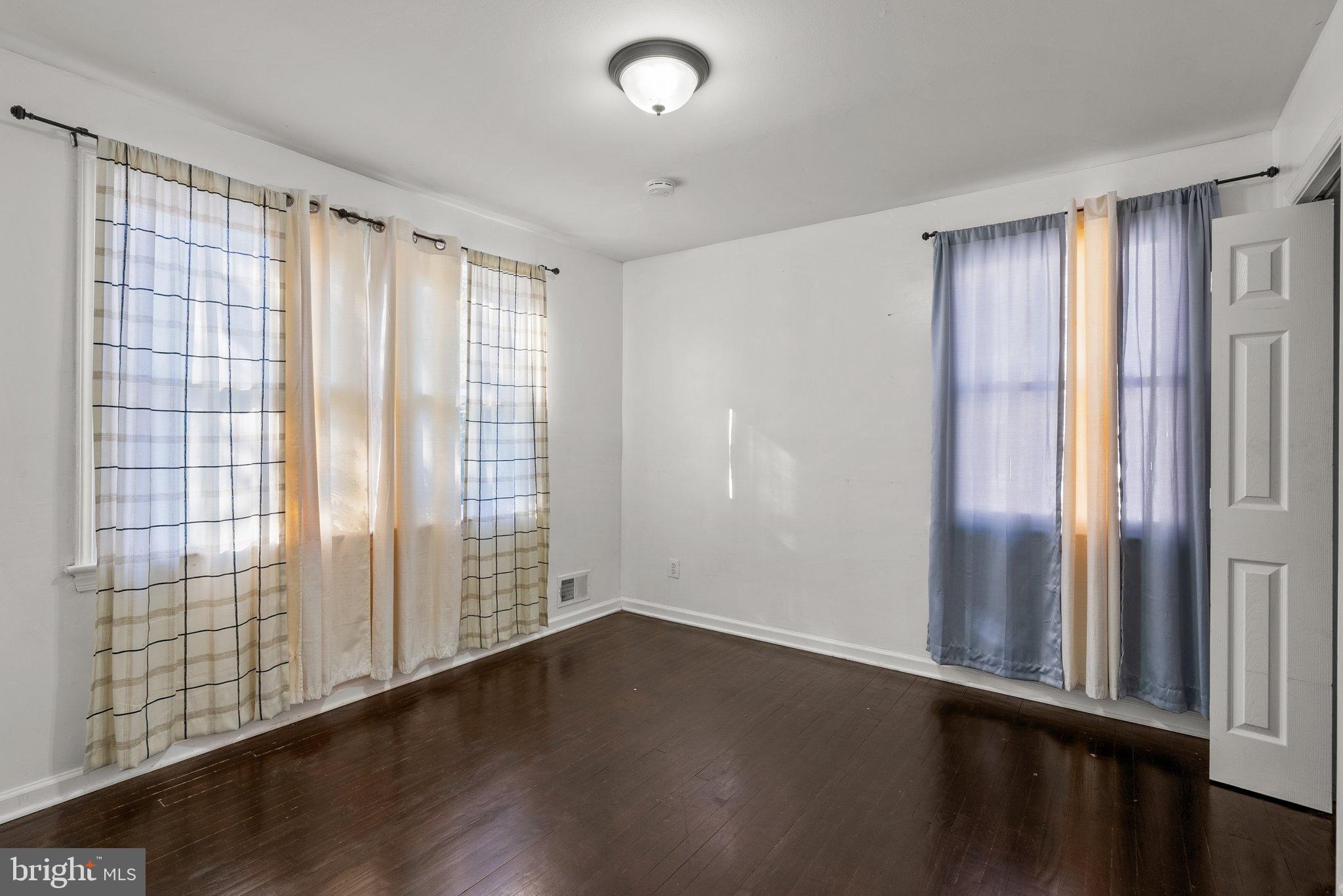 5122 Decatur Street Hyattsville, MD 20781 - Photo 12 of 22 a view of an empty room with wooden floor and a window