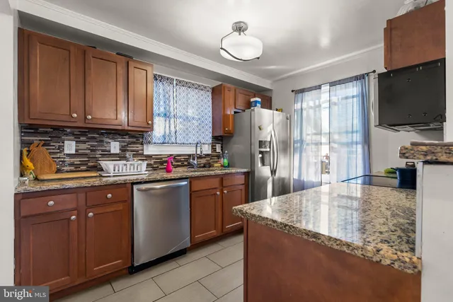 a kitchen with stainless steel appliances granite countertop a stove refrigerator and microwave