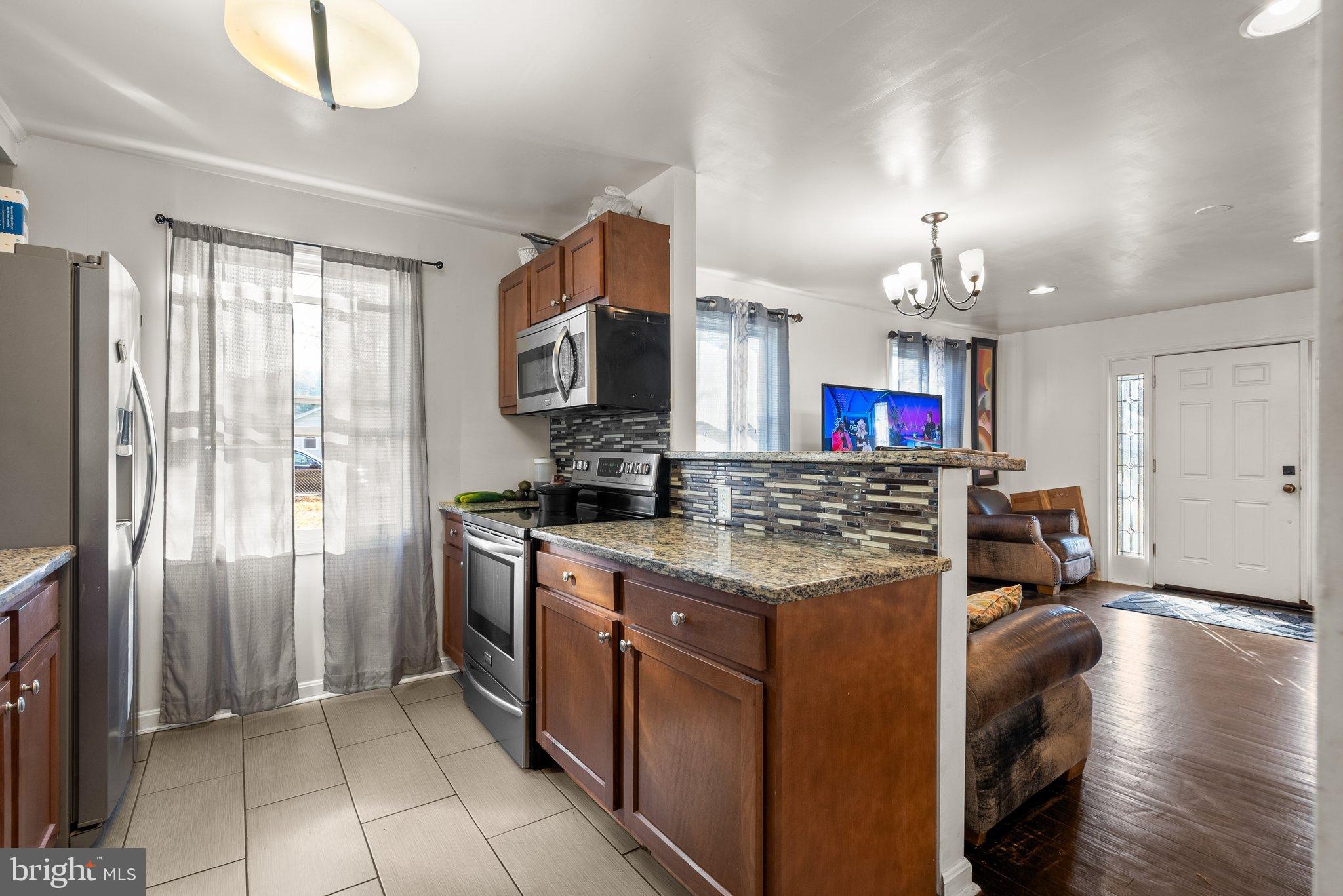 5122 Decatur Street Hyattsville, MD 20781 - Photo 8 of 22 a kitchen with stainless steel appliances granite countertop a sink stove and refrigerator
