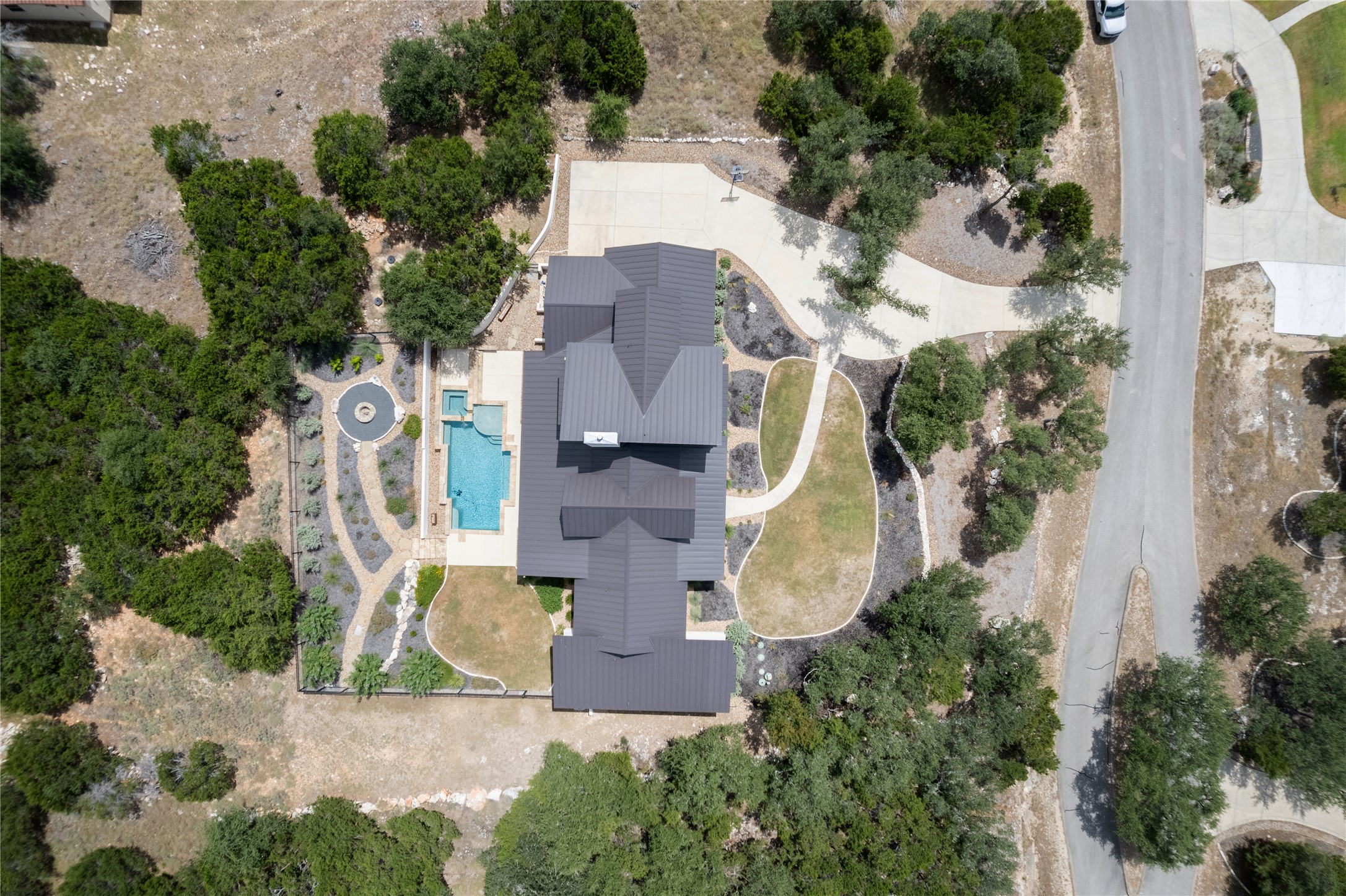 27619 Sunset Loop Garden Ridge, TX 78266 - Photo 34 of 39 An aerial perspective showcases a private property surrounded by dense trees and custom hardscaping.