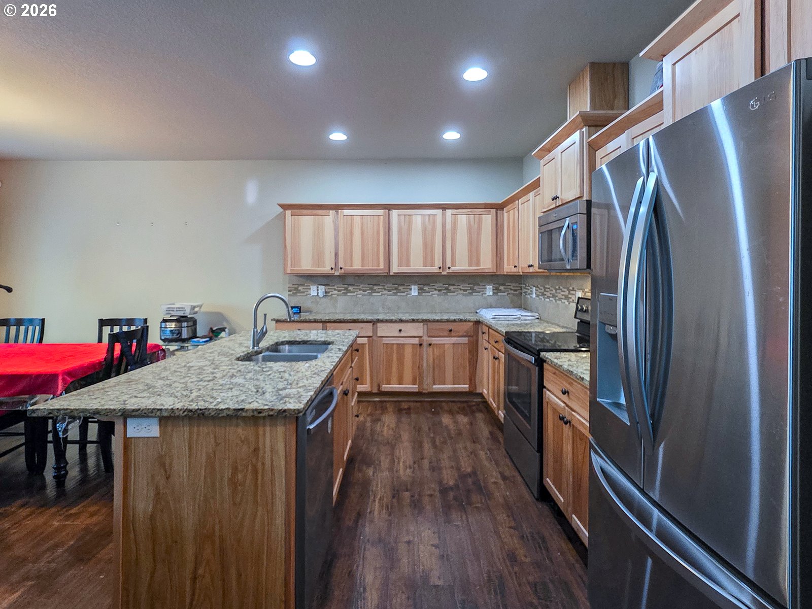 2838 26th Avenue Forest Grove, OR 97116 - Photo 8 of 37 a kitchen with stainless steel appliances granite countertop a refrigerator a sink dishwasher a stove and white countertops with wooden floor