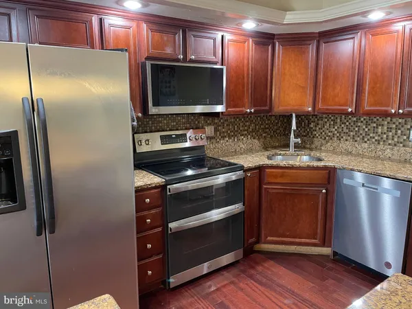 a kitchen with stainless steel appliances and wooden cabinets