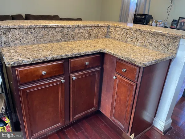 a utility room with granite countertop cabinets and sink