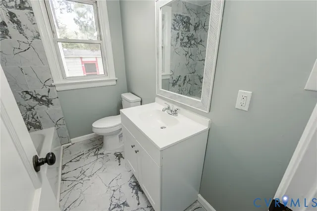 a bathroom with a sink toilet and window