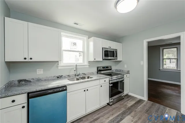 a kitchen with a sink stove top oven and microwave