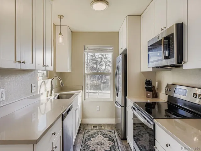 a kitchen with stainless steel appliances granite countertop a sink stove and microwave