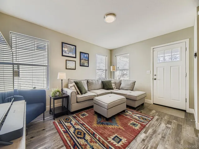 a spacious bedroom with a bed a couch and two windows