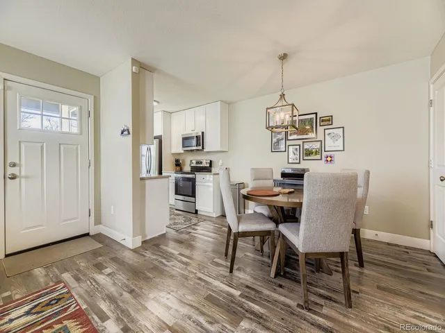 a dining room with furniture wooden floor a rug and a chandelier