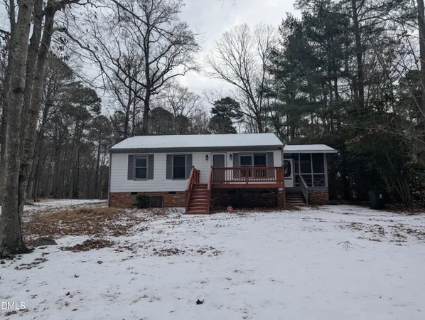 a front view of a house with a yard covered with snow in front of house