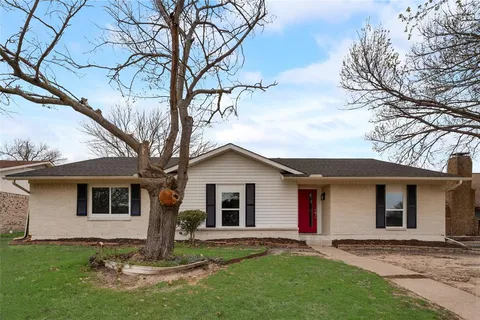 a view of a yard in front of a house with large tree