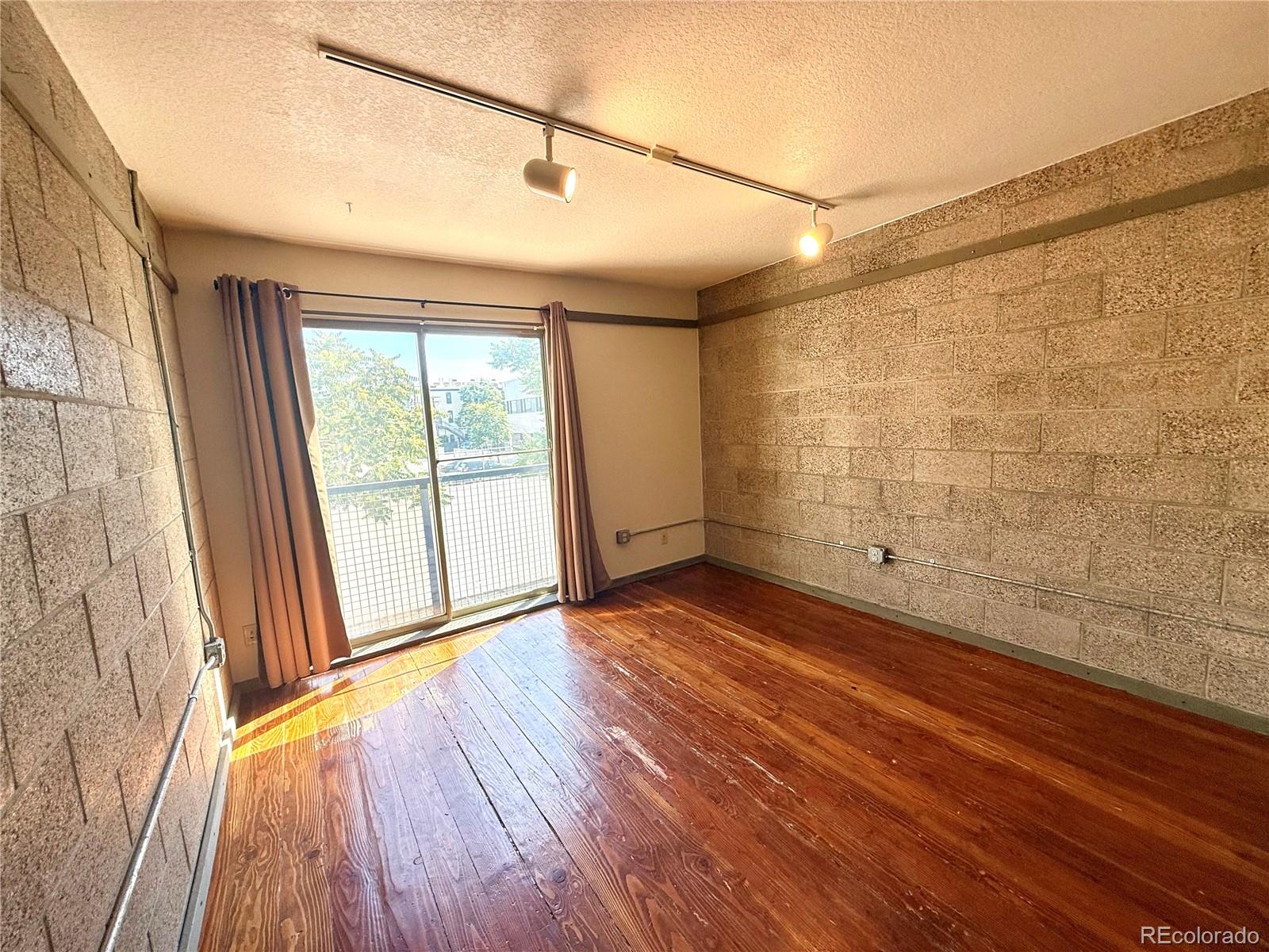 a view of a big room with wooden floor and windows