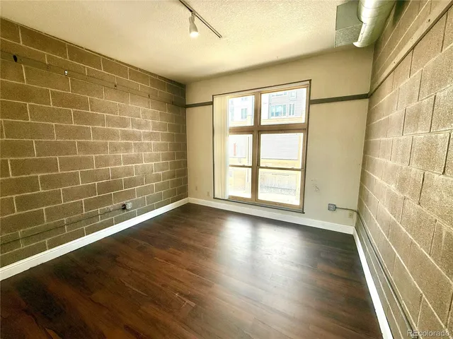 a view of a livingroom with wooden floor and a window