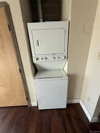 a utility room with wooden floor washer and dryer