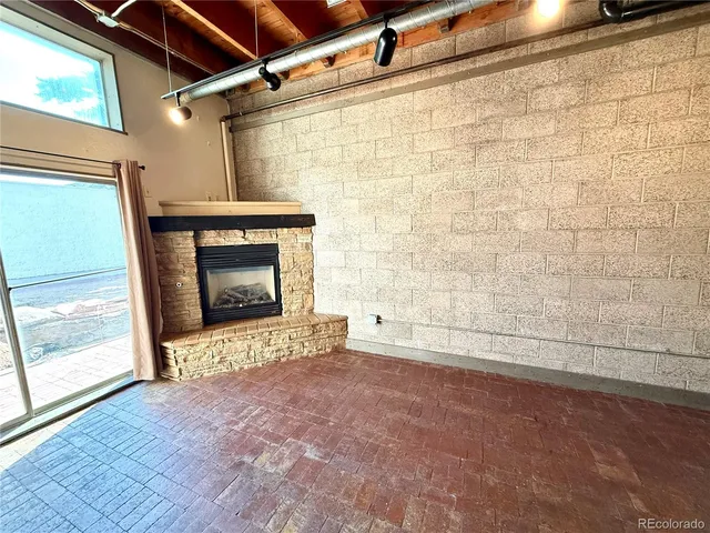 a view of empty room with a fireplace and wooden floor