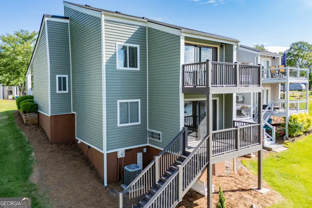 an aerial view of a house with swimming pool and large trees