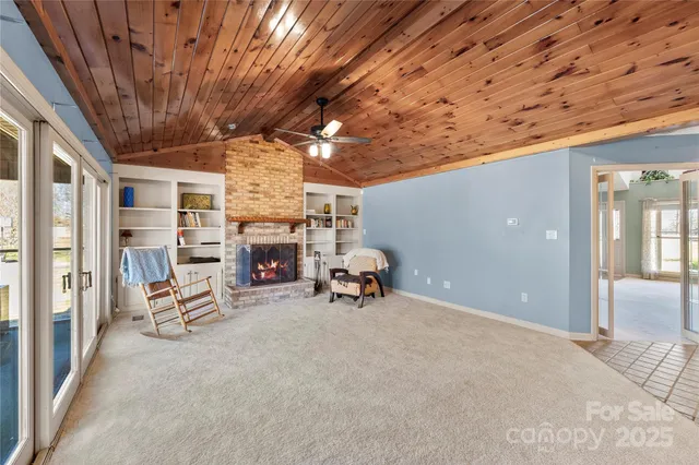 an empty room with windows and chandelier fan