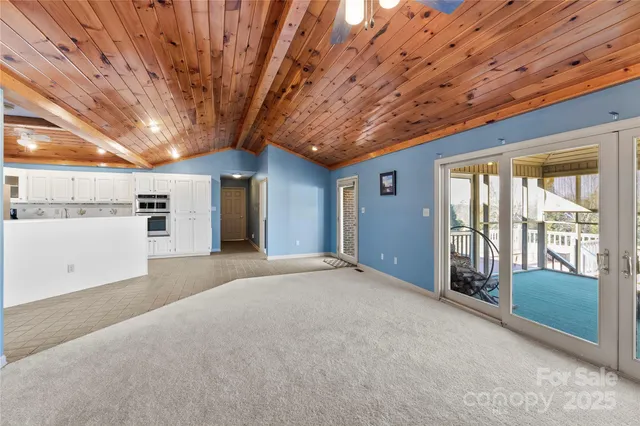 an empty room with windows and chandelier fan