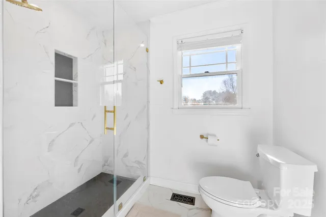 a living room with furniture a ceiling fan and a large window