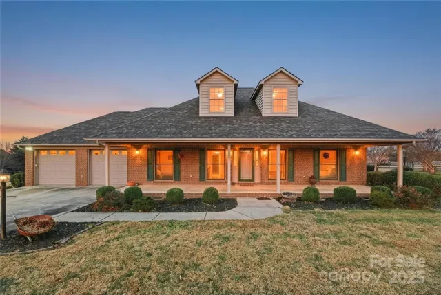 a front view of house with yard and trees in the background