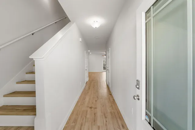 a view of a hallway with wooden floor and staircase