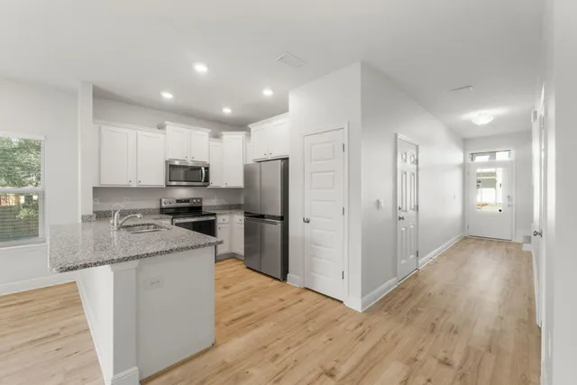 a kitchen with stainless steel appliances granite countertop a refrigerator and a stove top oven