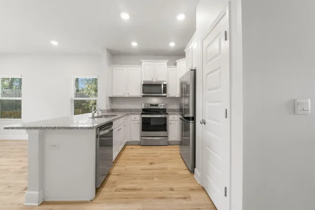 a kitchen with a sink a counter top space stainless steel appliances and cabinets