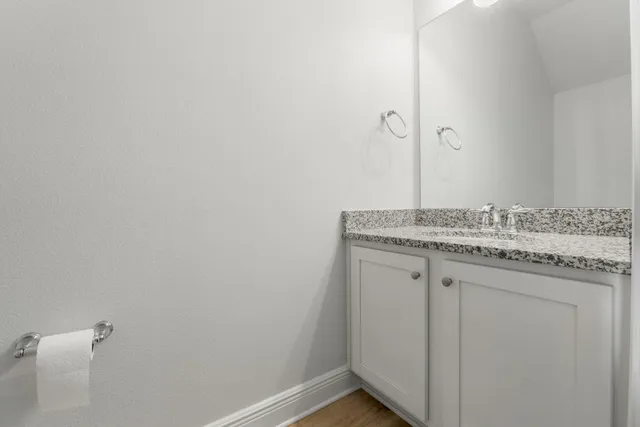 a bathroom with a granite countertop sink and vanity