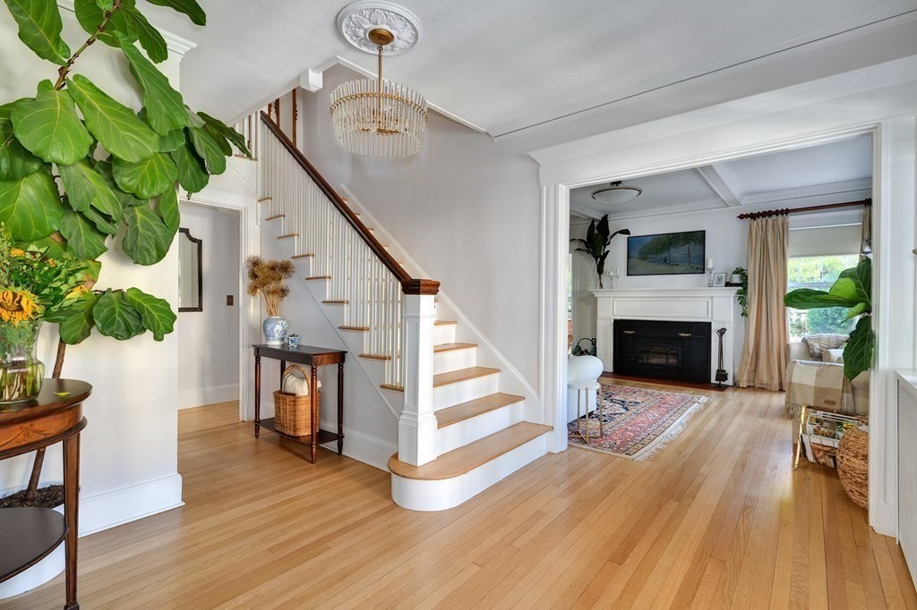 104 Manet Road Newton, MA 02467 - Photo 4 of 24 a view of a livingroom with furniture a fireplace wooden floor and windows
