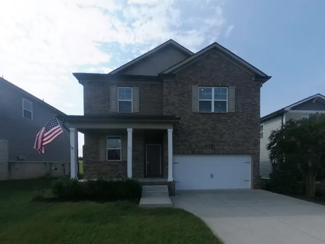 a front view of a house with a yard and a garden