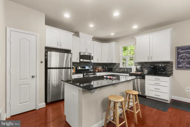 a kitchen with white cabinets and stainless steel appliances