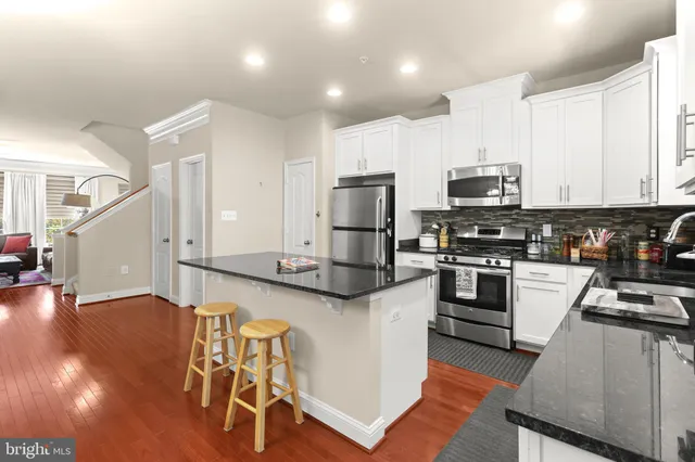 a kitchen with stainless steel appliances kitchen island granite countertop a stove a sink and a microwave