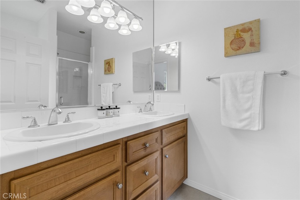 233 Danbrook Irvine, CA 92603 - Photo 22 of 32 a bathroom with a double vanity sink mirror and chandelier