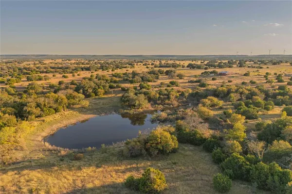 an aerial view of residential house with space and trees all around