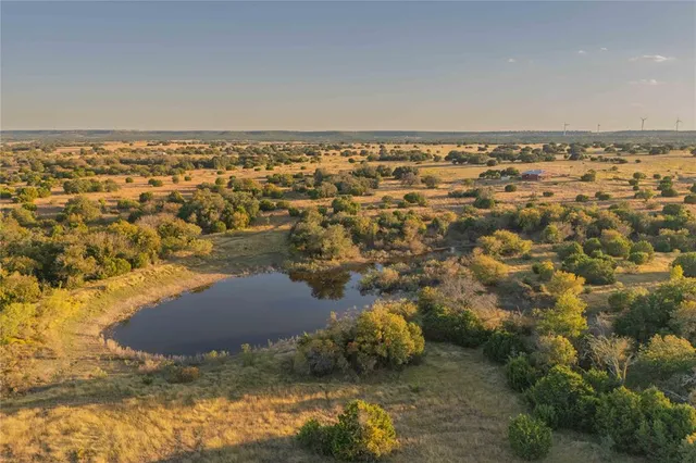 an aerial view of residential house with space and trees all around