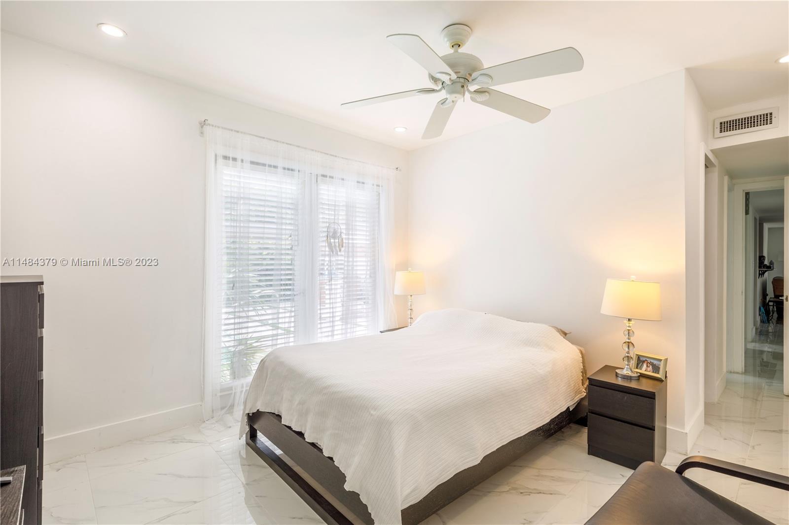 1990 Keystone Boulevard North Miami, FL 33181 - Photo 11 of 20 a bedroom with a bed and a chandelier