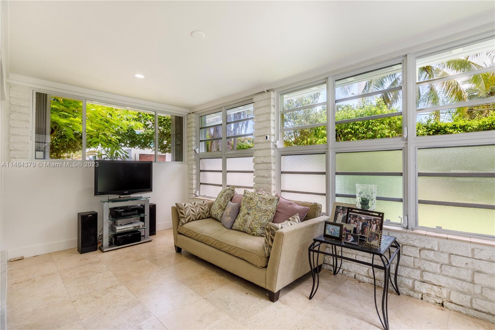 1990 Keystone Boulevard North Miami, FL 33181 - Photo 7 of 20 a living room with furniture a flat screen tv and a floor to ceiling window