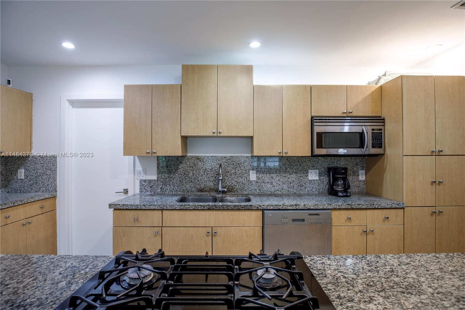 1990 Keystone Boulevard North Miami, FL 33181 - Photo 9 of 20 a kitchen with a sink stove and refrigerator