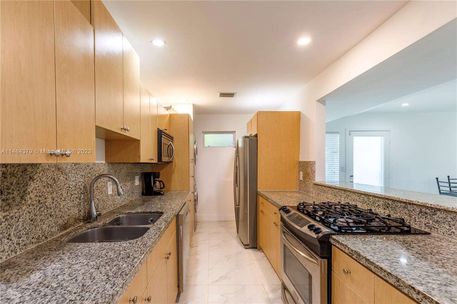 1990 Keystone Boulevard North Miami, FL 33181 - Photo 10 of 20 a kitchen with granite countertop stainless steel appliances a sink stove and refrigerator