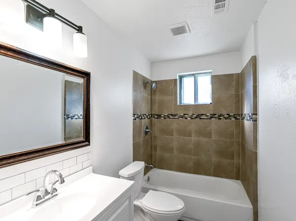 a bathroom with a granite countertop sink toilet and shower